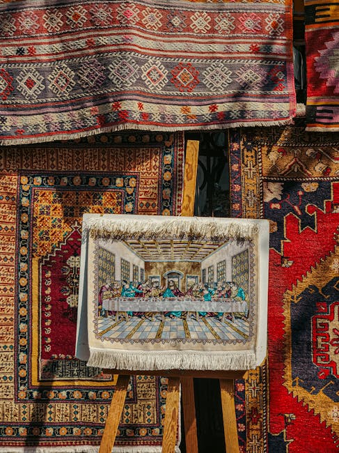 Exterior view of Gipsy Hill Carpet Cleaners shop showcasing a display of various rugs and carpets outside the store. A large, intricately patterned blue and beige rug is propped vertically next to a n